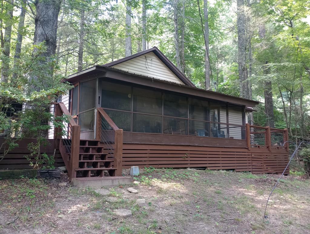 a backyard of a house with wooden fence and large tree