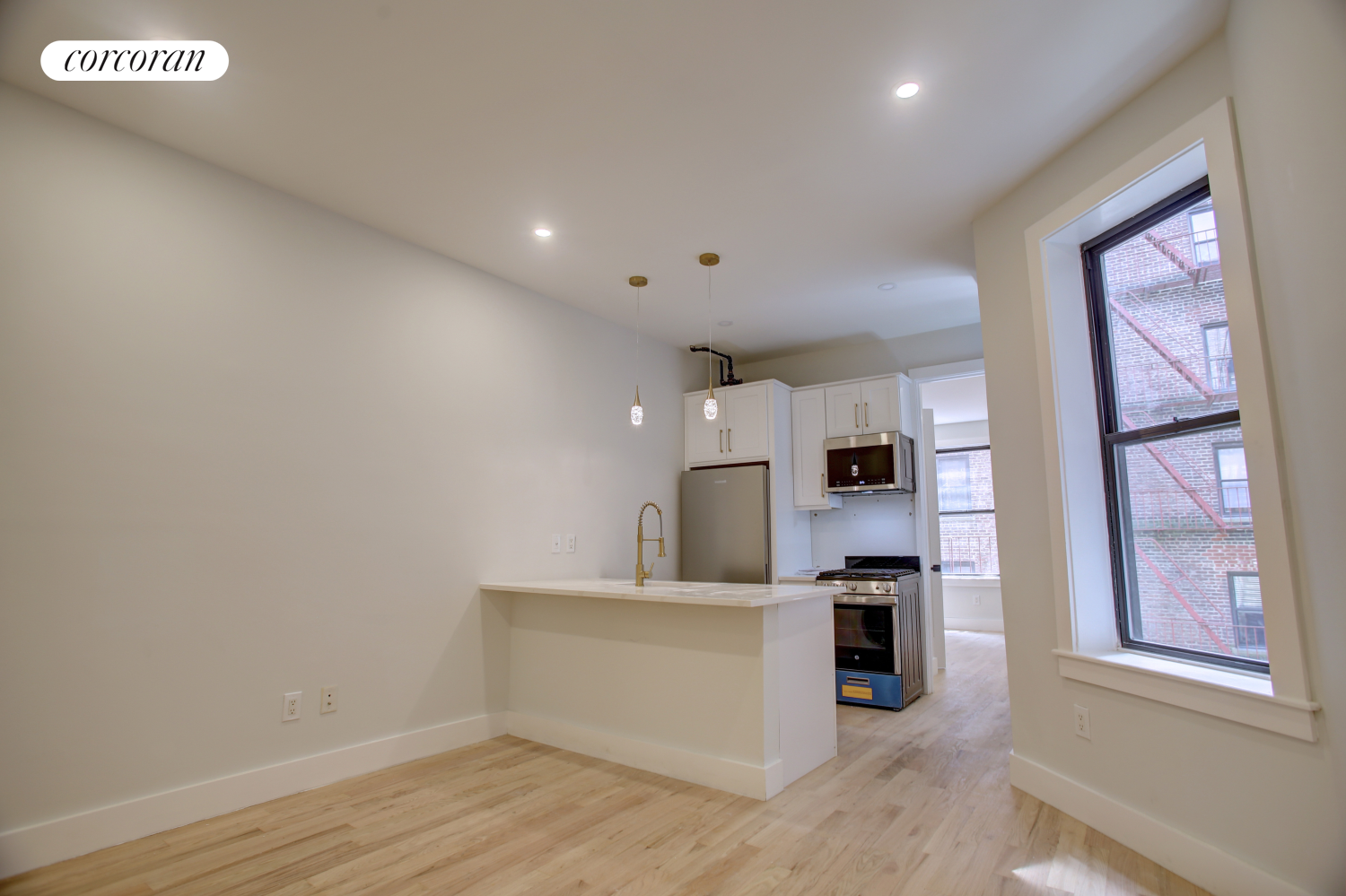 a view of a kitchen with furniture and wooden floor