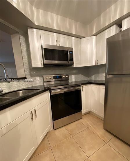 a kitchen with stainless steel appliances a refrigerator sink and microwave