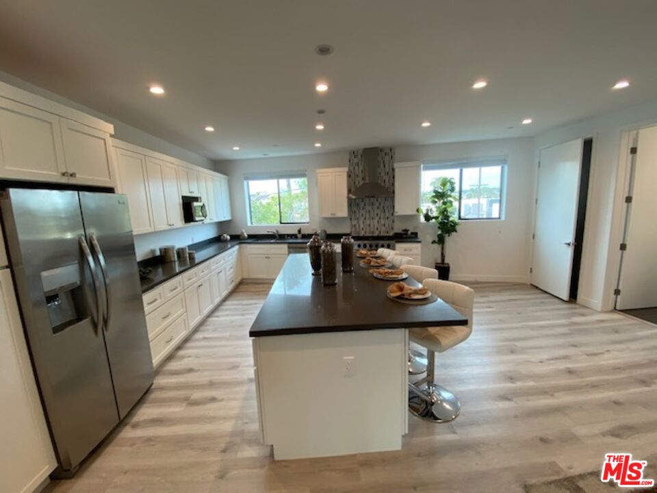 a kitchen with stainless steel appliances granite countertop a sink a stove and a refrigerator