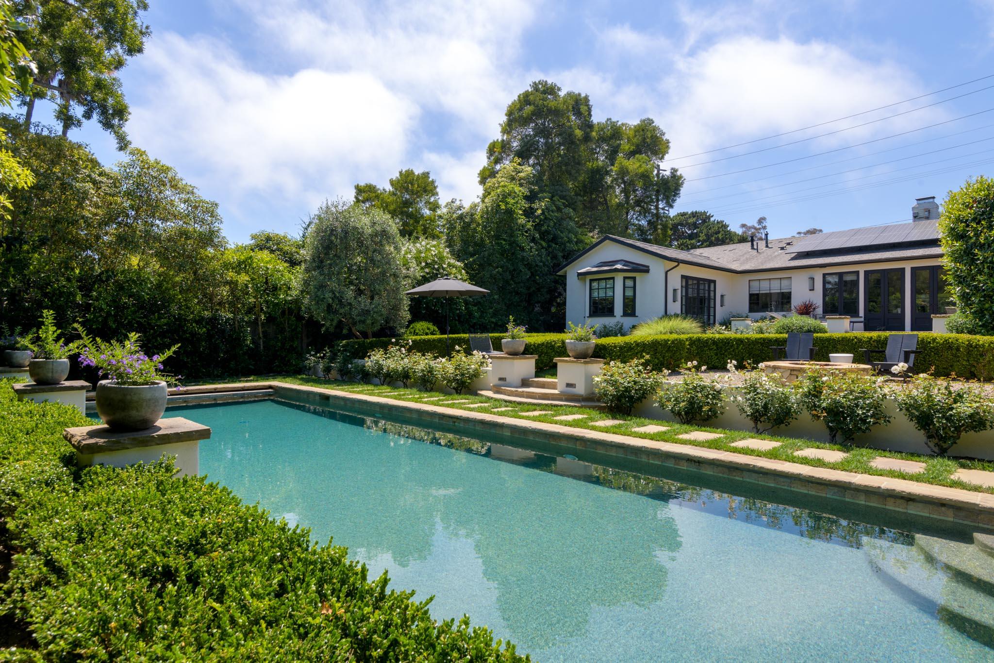 a front view of a house with swimming pool having outdoor seating