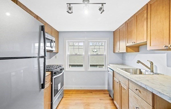 a kitchen with stainless steel appliances granite countertop a sink stove and refrigerator