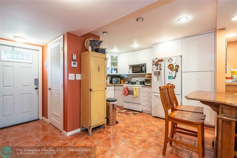 a view of kitchen with stainless steel appliances granite countertop dining table and chairs