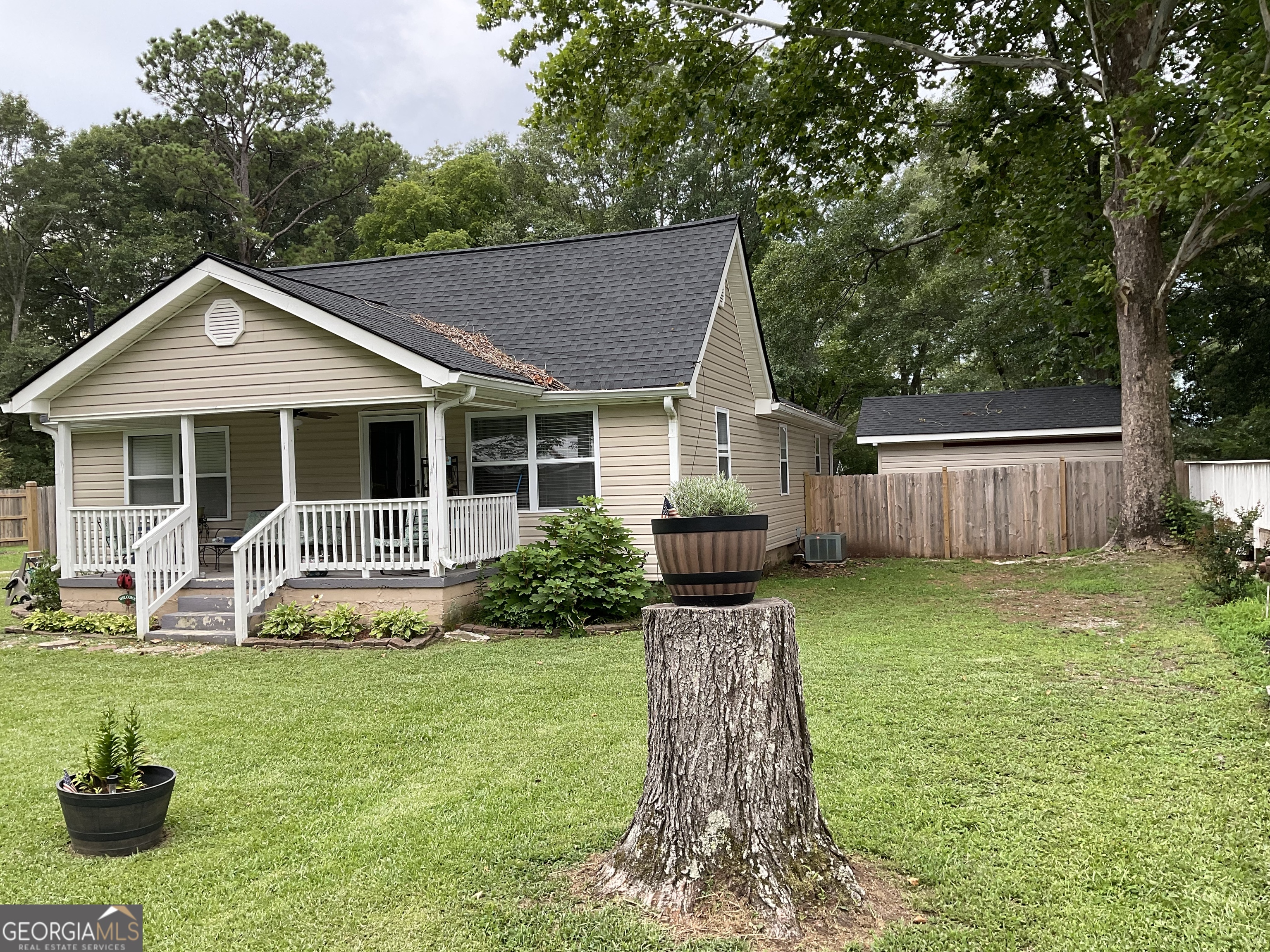 a front view of house with yard and glass top table and chairs