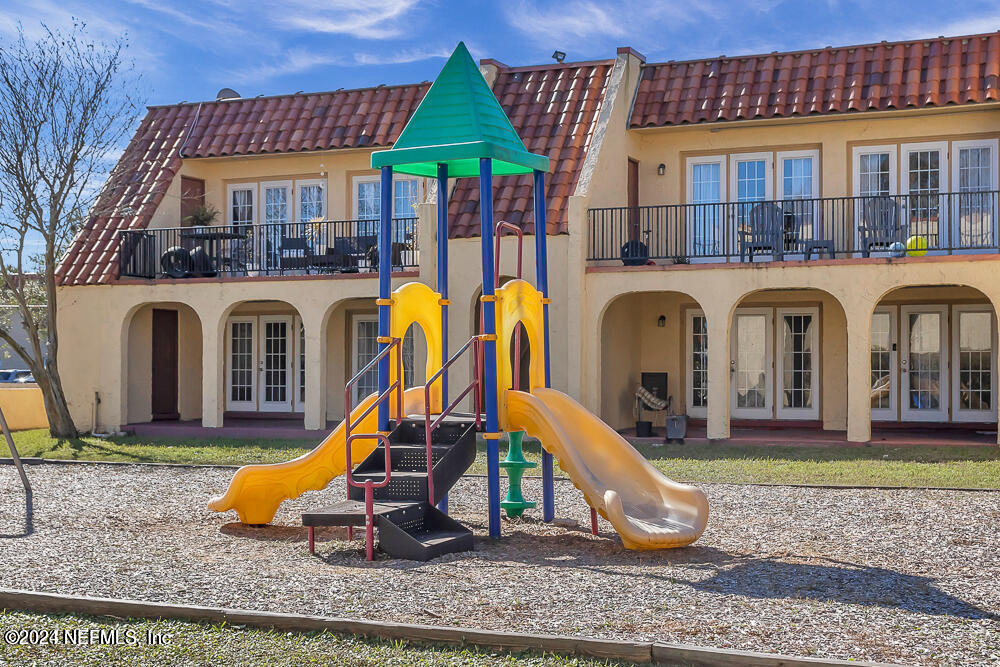 a view of a house with a yard patio and a slide