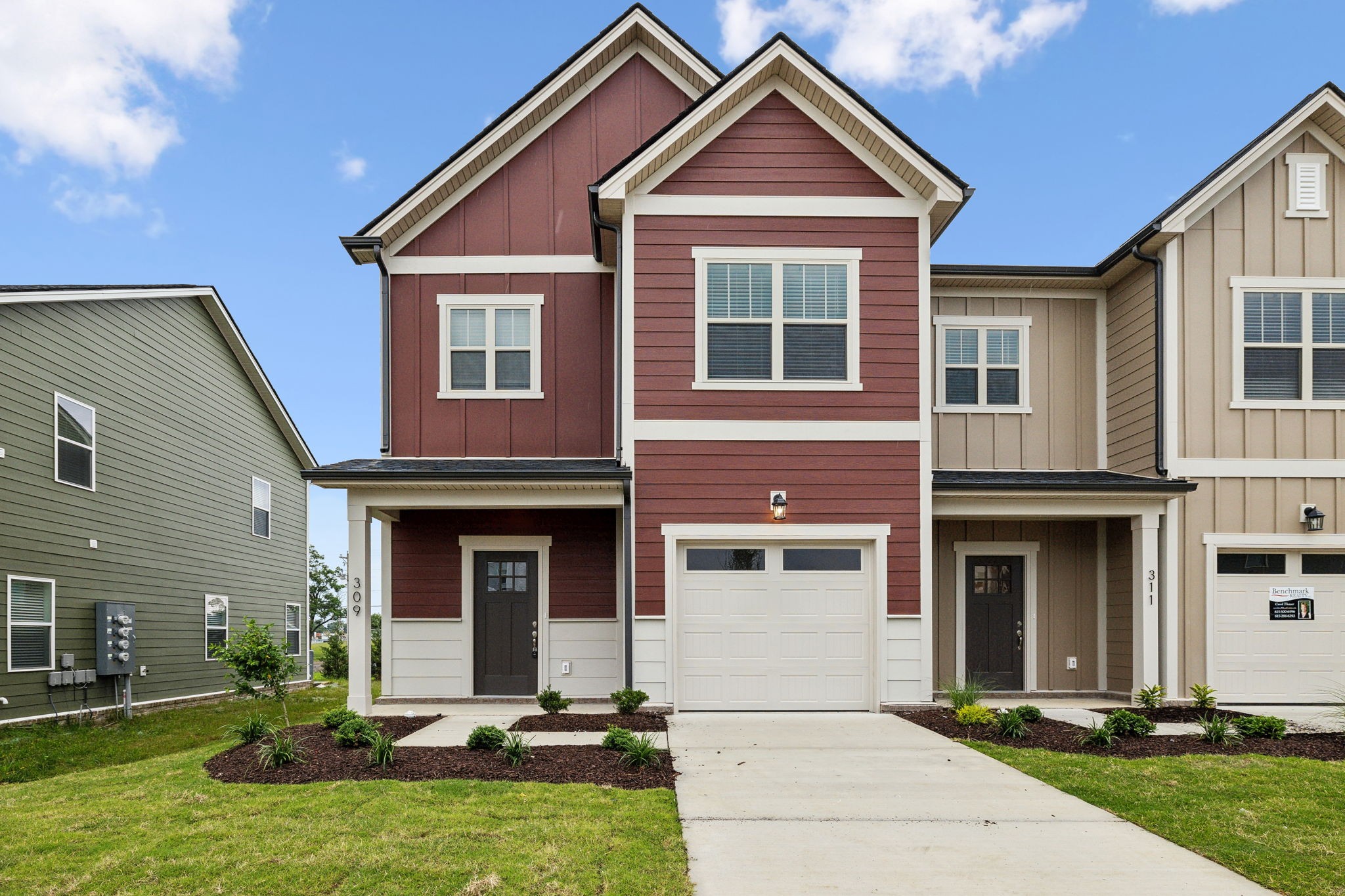 a front view of a house with yard and garage