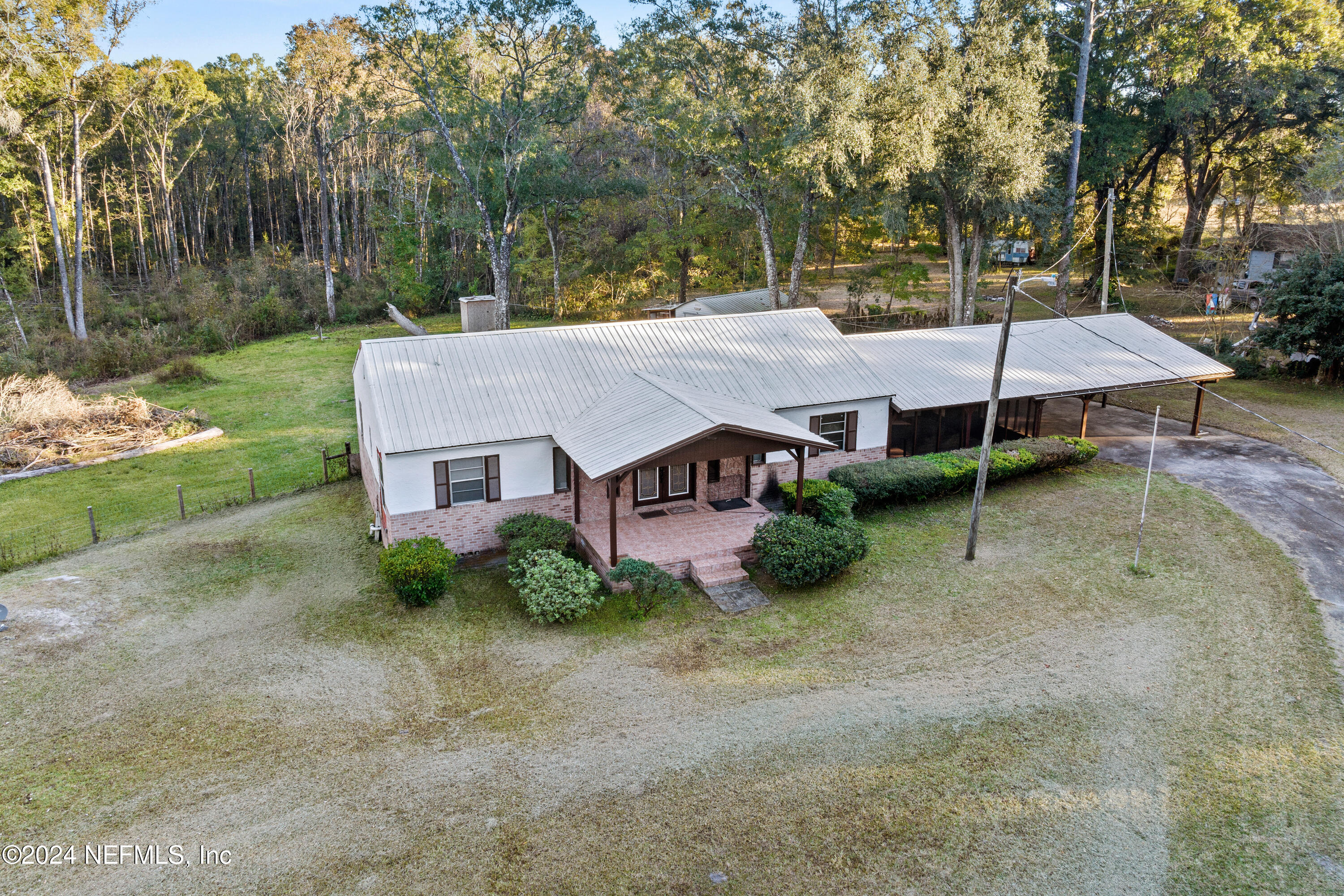 an aerial view of a house with a yard and large tree