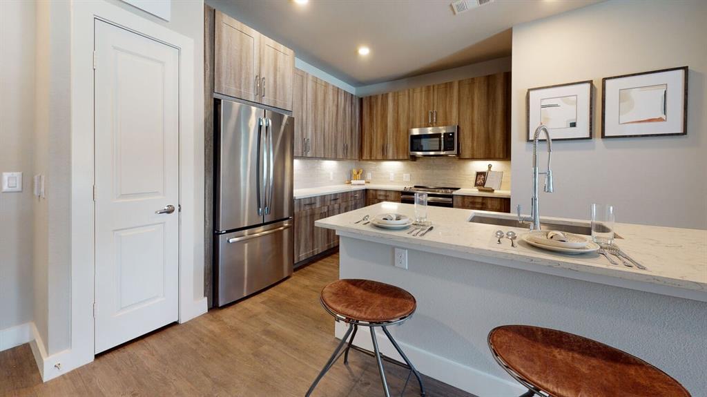 a kitchen with stainless steel appliances granite countertop a sink refrigerator and microwave