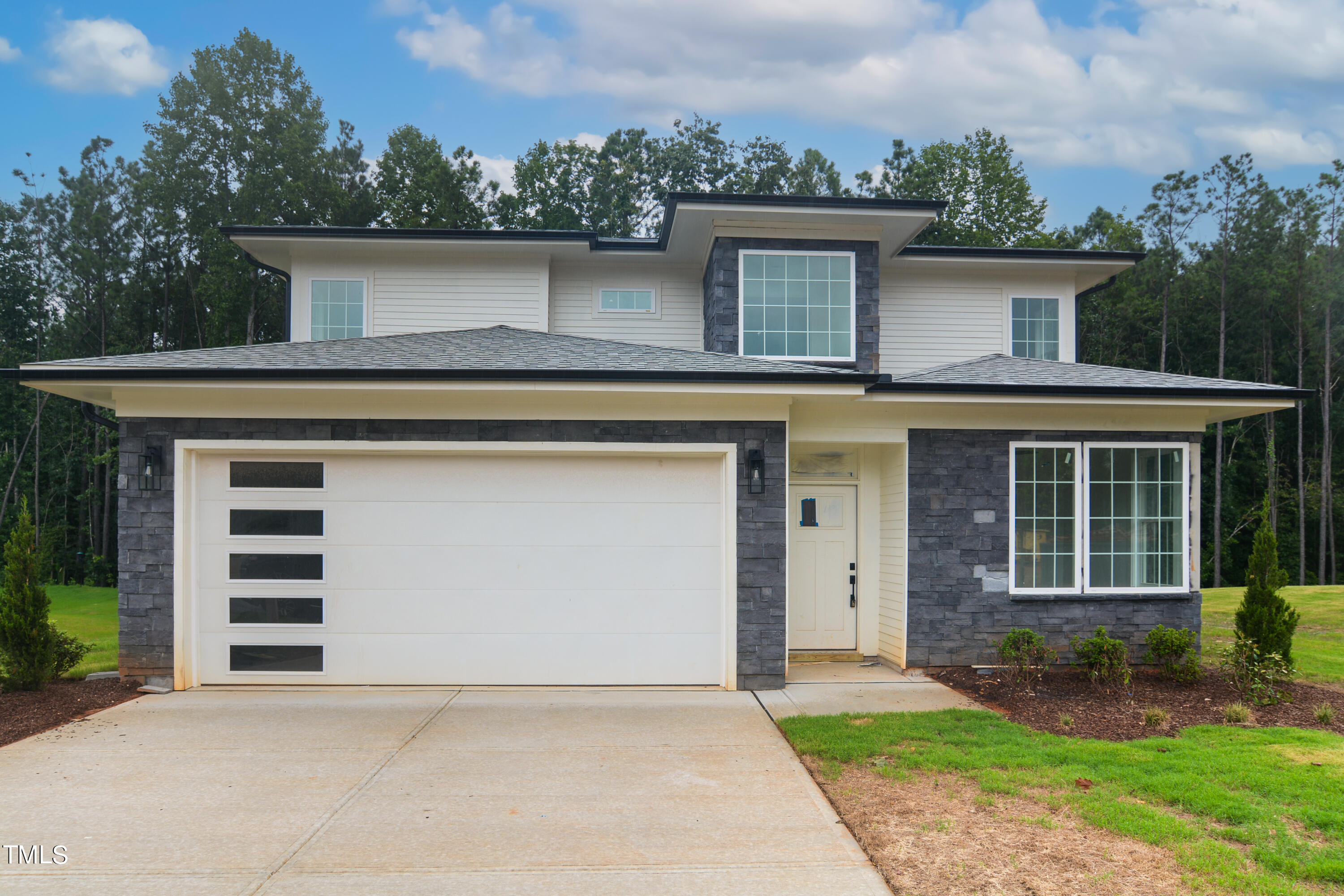 a front view of a house with a garden and garage