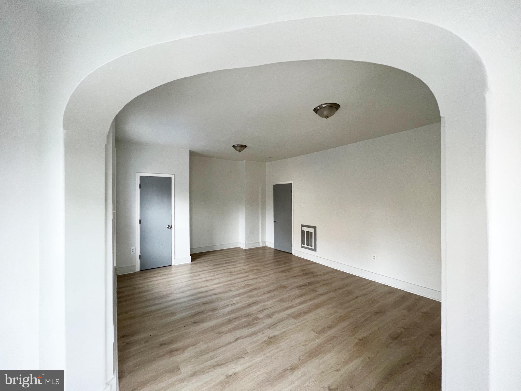 a view of an empty room with wooden floor