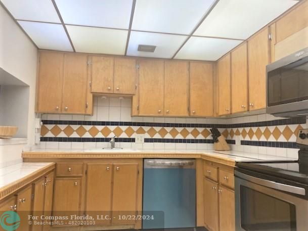 a kitchen with stainless steel appliances a sink and cabinets