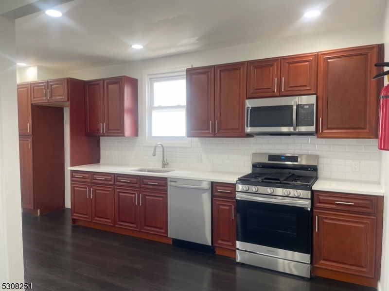 a kitchen with stainless steel appliances wooden cabinets and a stove top oven