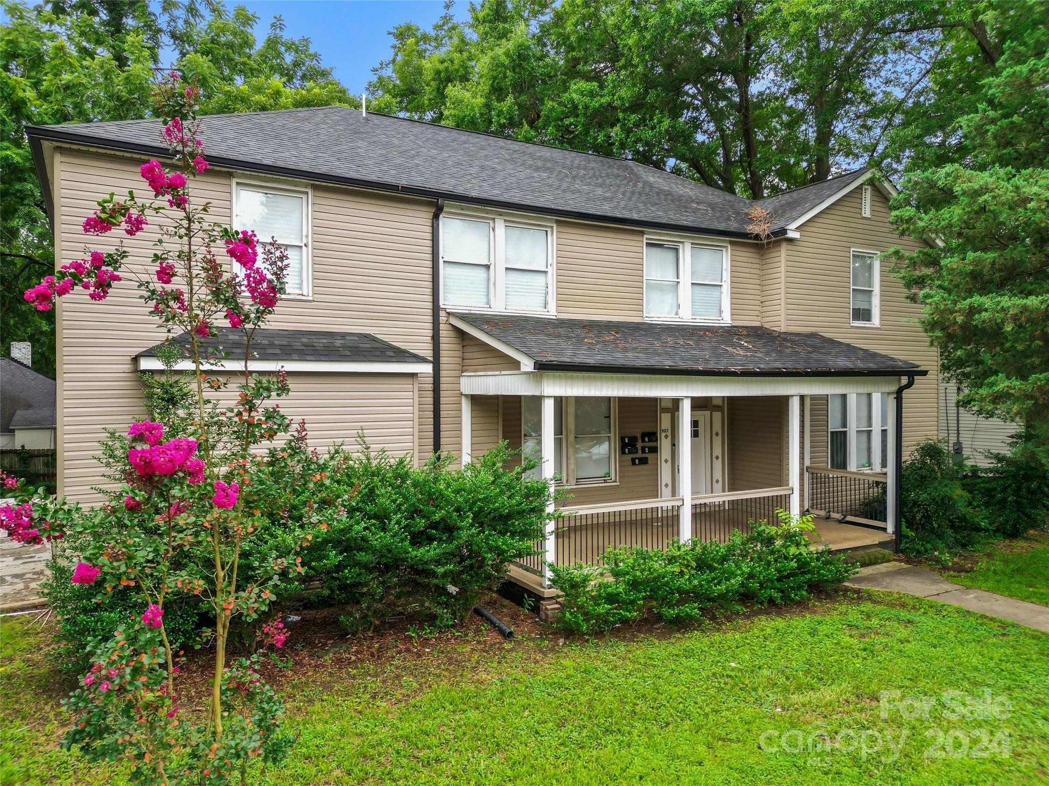 a front view of a house with a yard and potted plants