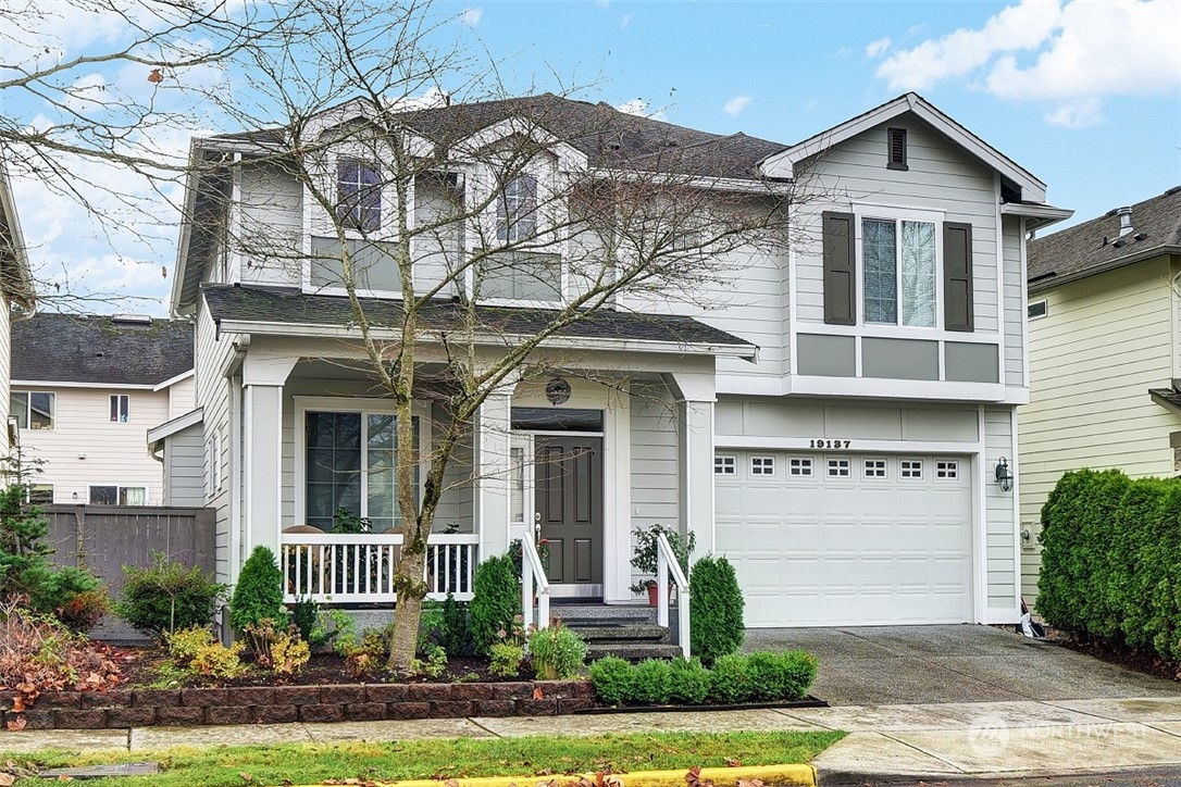 a front view of a house with a yard and potted plants