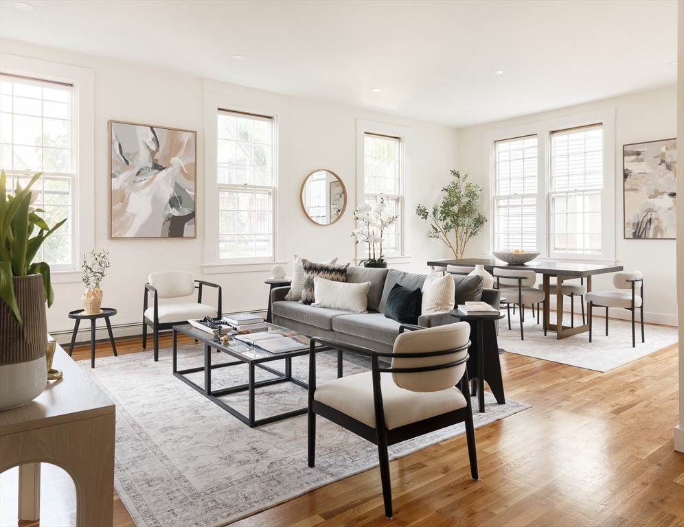 a living room with furniture wooden floor and a large window