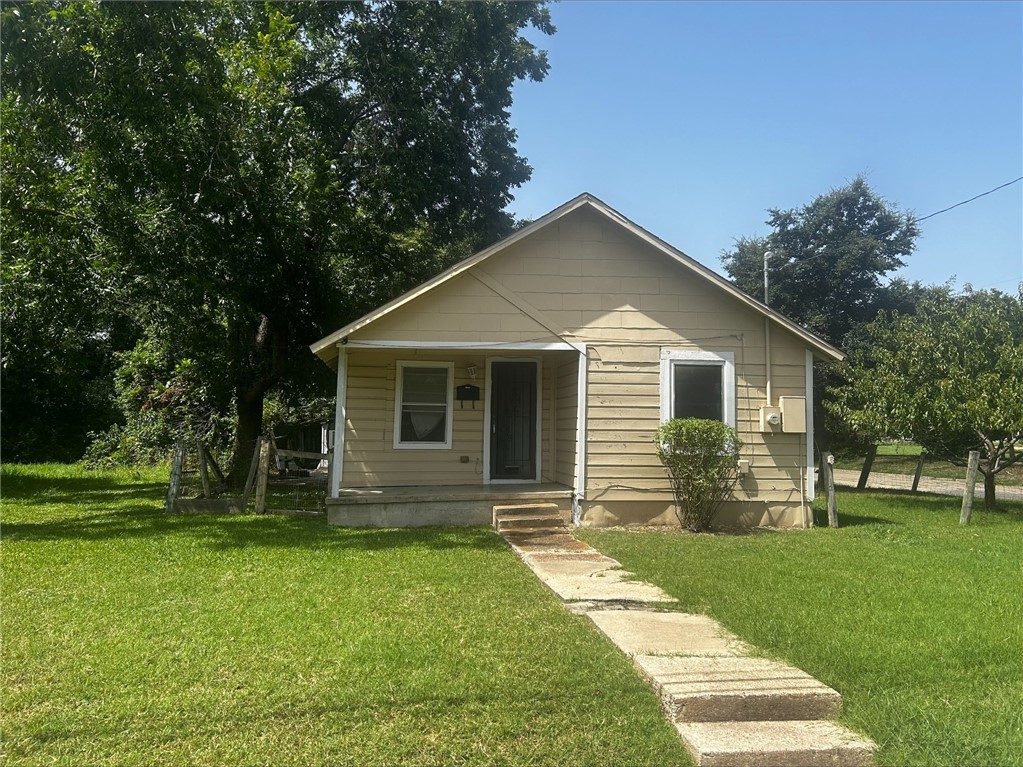 a front view of house with a garden and patio