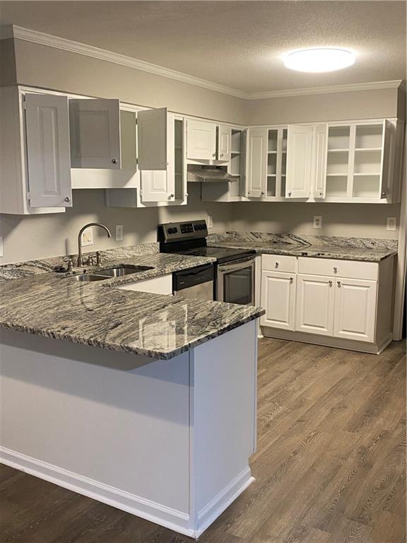 a kitchen with granite countertop cabinets a stove a sink and a counter space