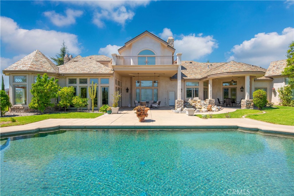 a view of a house with swimming pool and a yard