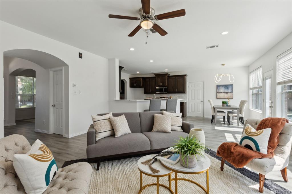 a living room with furniture kitchen view and a chandelier