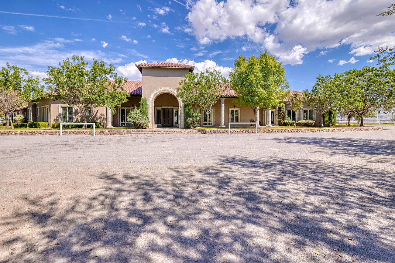 a front view of a house with a yard and trees