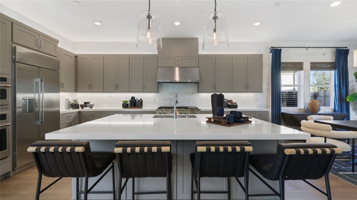 a kitchen with a dining table chairs and refrigerator