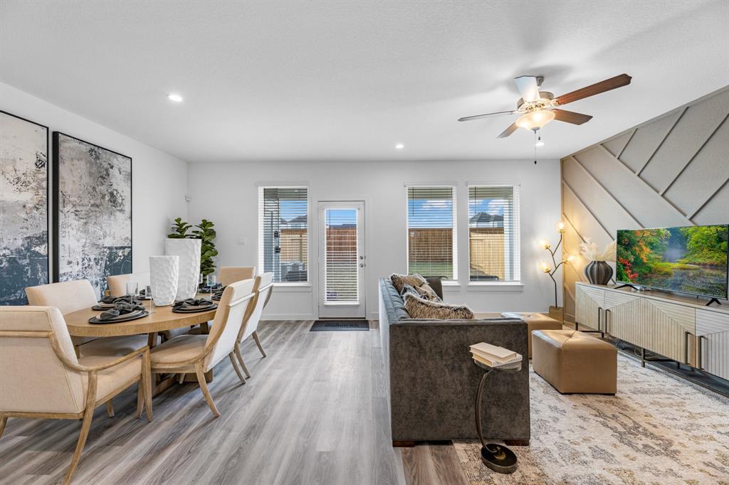 a living room with furniture a flat screen tv and a large window