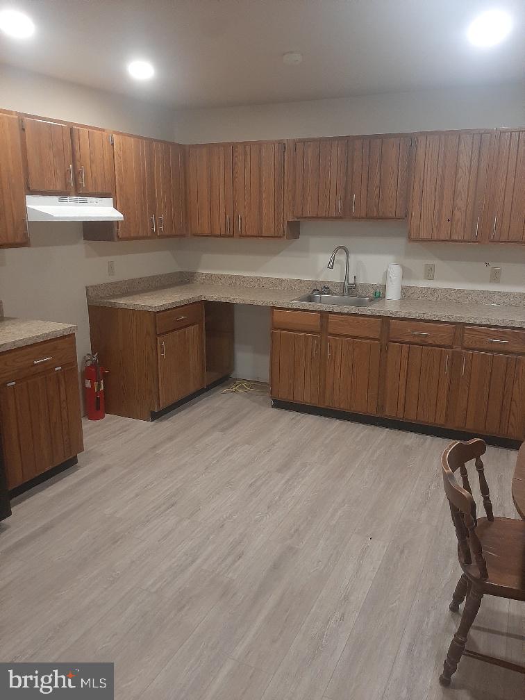 a kitchen with granite countertop a sink cabinets and stainless steel appliances