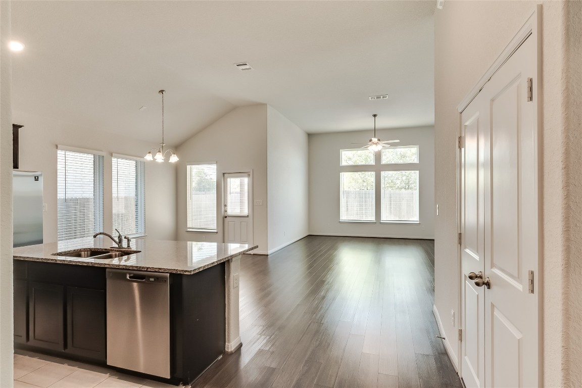 a kitchen with kitchen island granite countertop a sink and a stove top oven