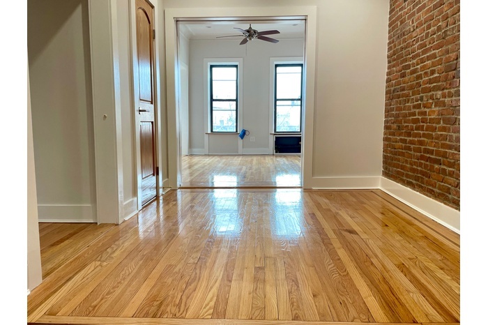 a view of a room with wooden floor and a window