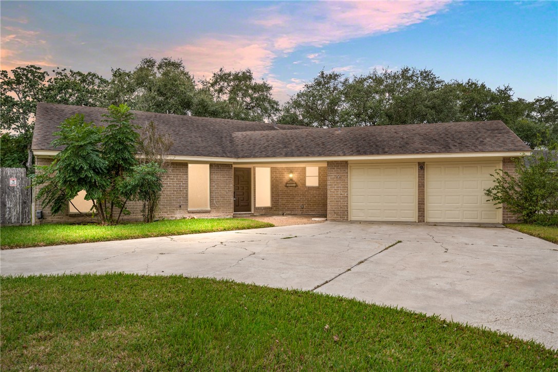 front view of house with a yard and trees