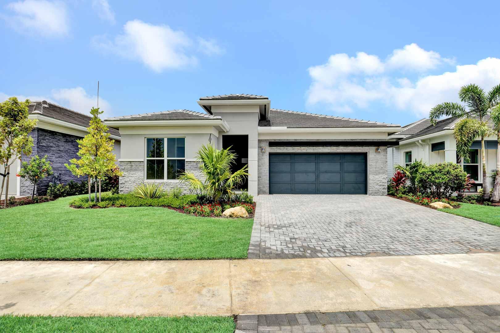 a front view of a house with a garden and plants