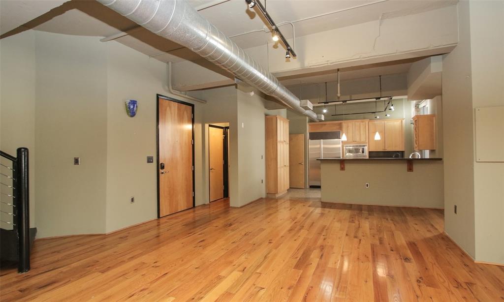 a view of a big room with wooden floor and windows