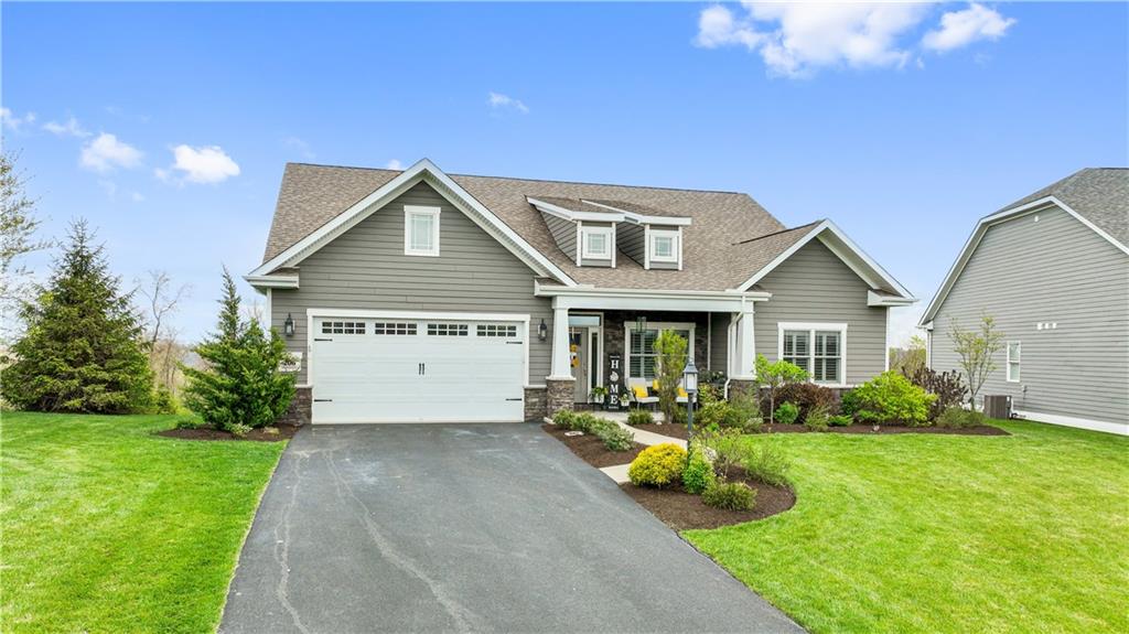 a front view of a house with yard and green space