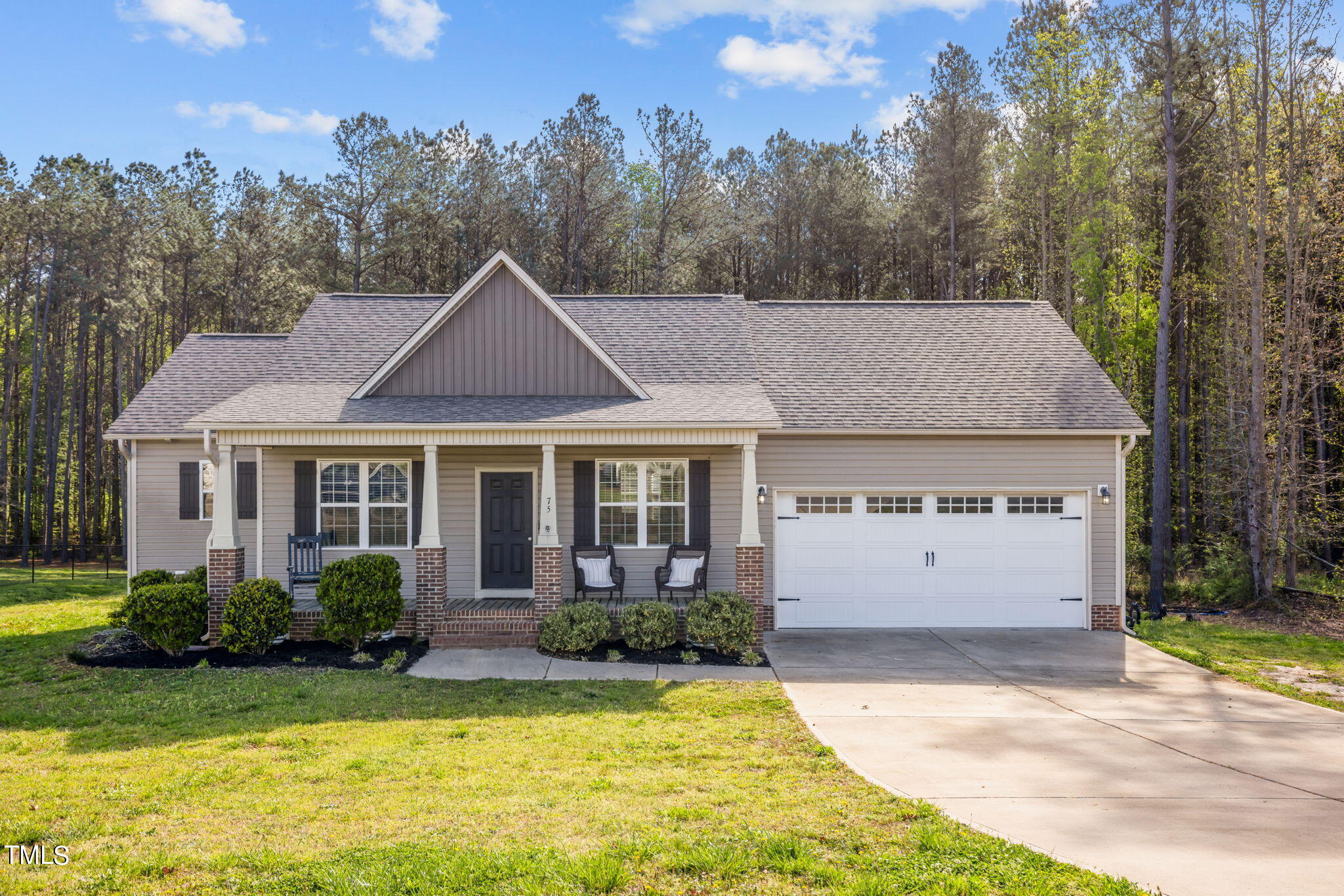 a front view of a house with a yard garage and outdoor seating