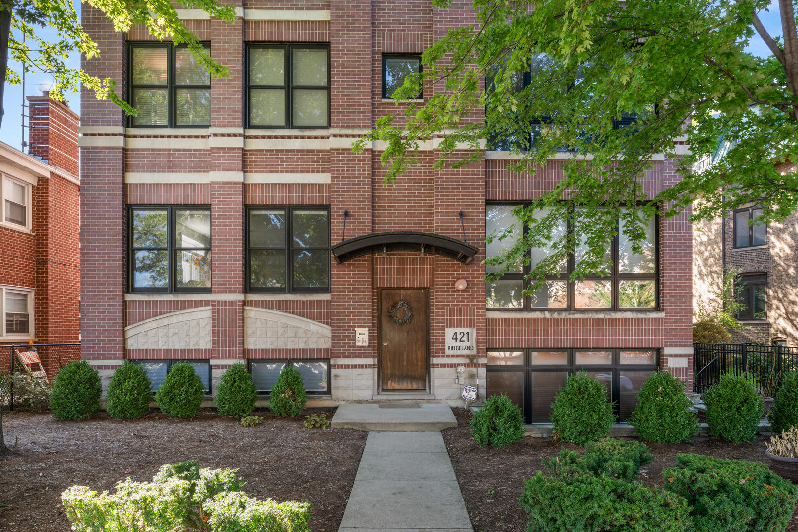 a front view of a building with a garden and plants