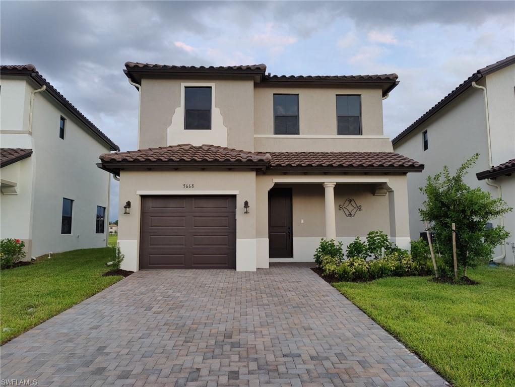 Mediterranean / spanish house featuring a garage and a front lawn