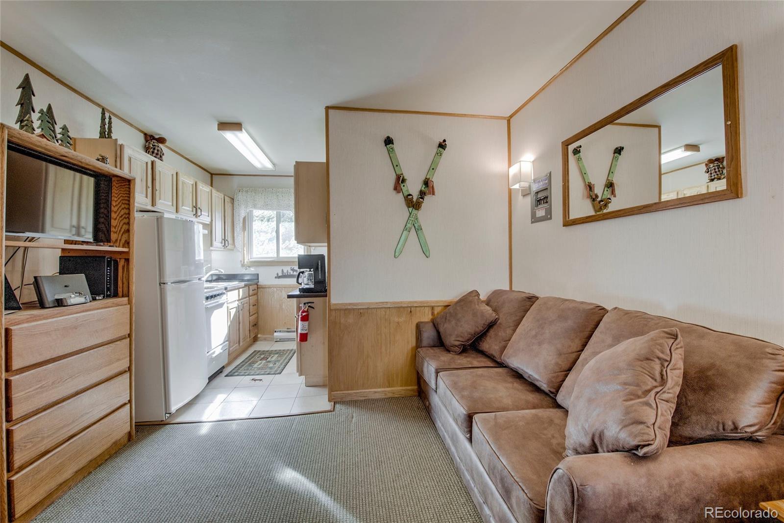 a living room with furniture and a kitchen view