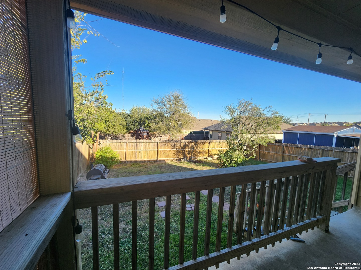 a view of a balcony with wooden floor & fence