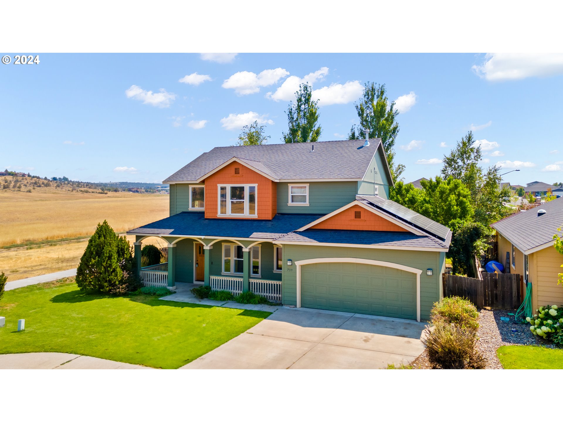 a aerial view of a house with a yard and potted plants