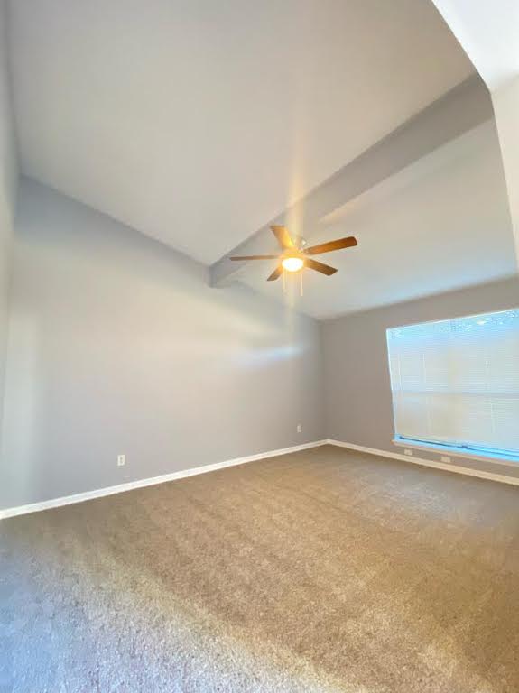 an empty room with a ceiling fan and carpet