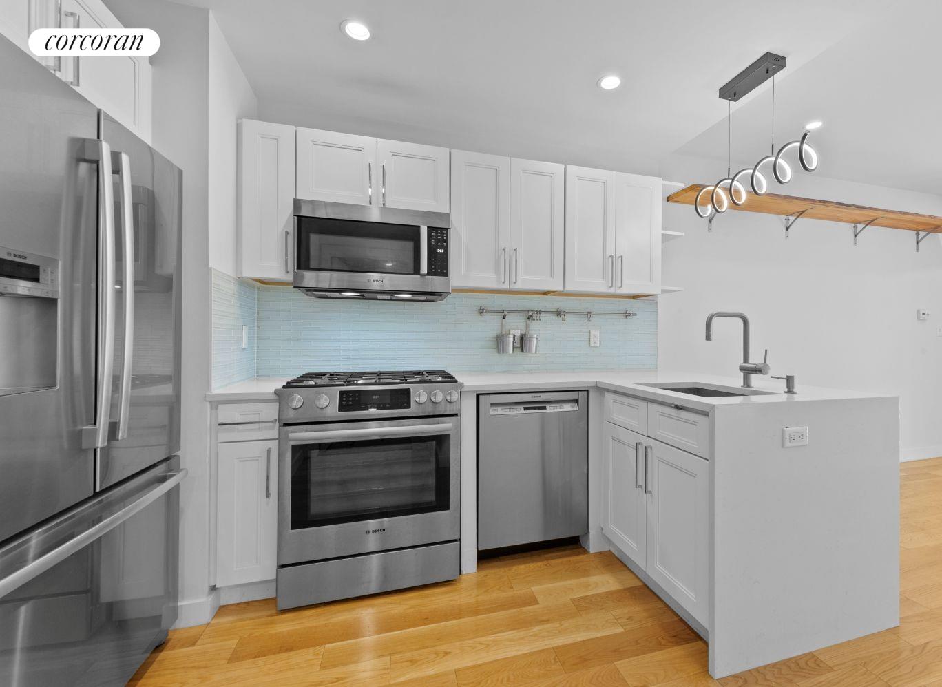 a kitchen with stainless steel appliances granite countertop a sink a stove a refrigerator and cabinets