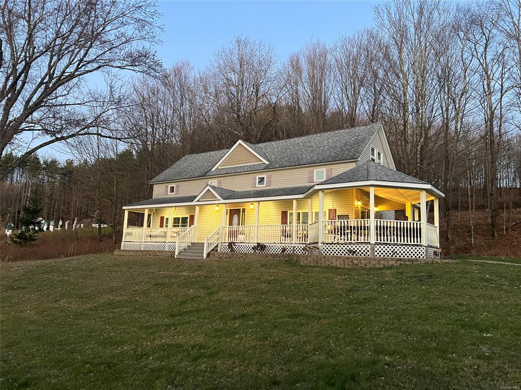 Farmhouse-style home with a front lawn and covered porch