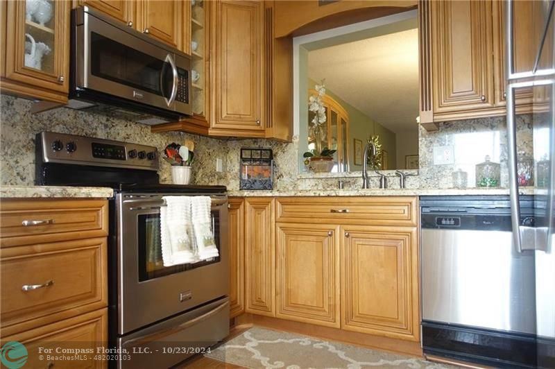 a kitchen with stainless steel appliances granite countertop a stove and a microwave