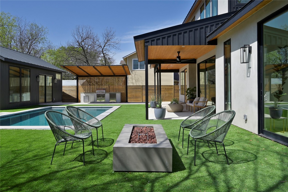 a view of a chair and table in backyard of the house