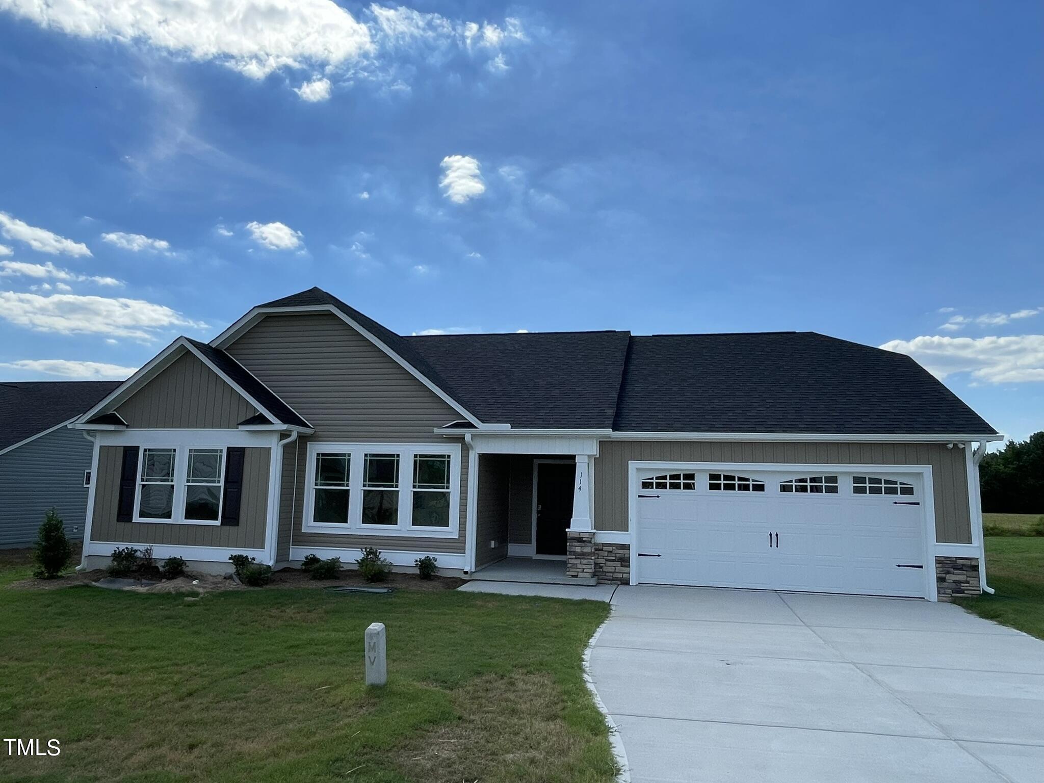 a front view of a house with a garden and yard