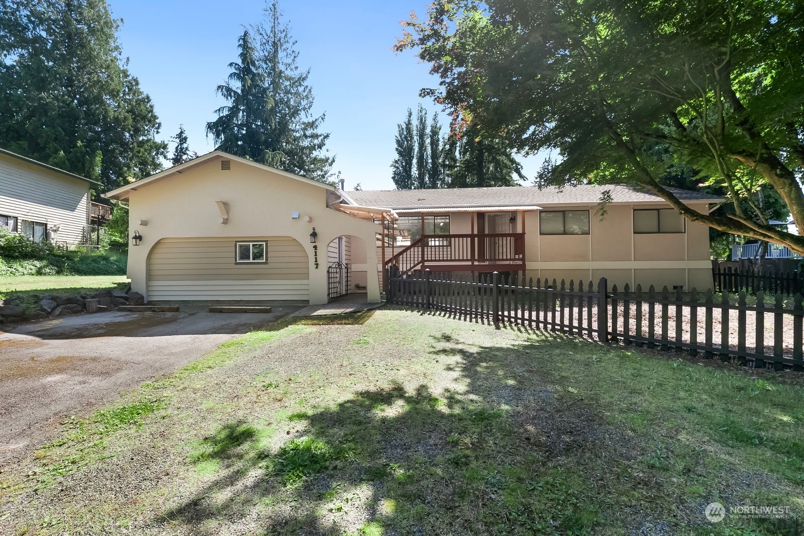 a view of a house with a yard and a large tree