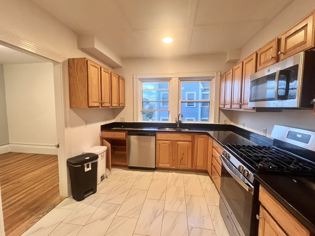 a kitchen with stainless steel appliances granite countertop a stove a sink and a microwave