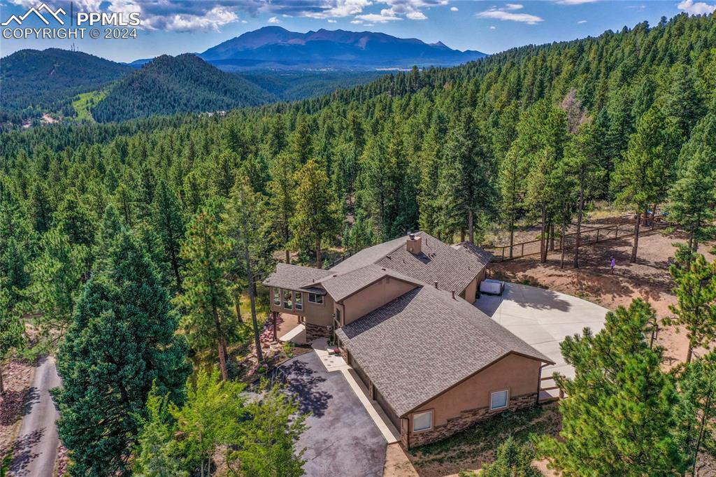 an aerial view of a house with yard and green space