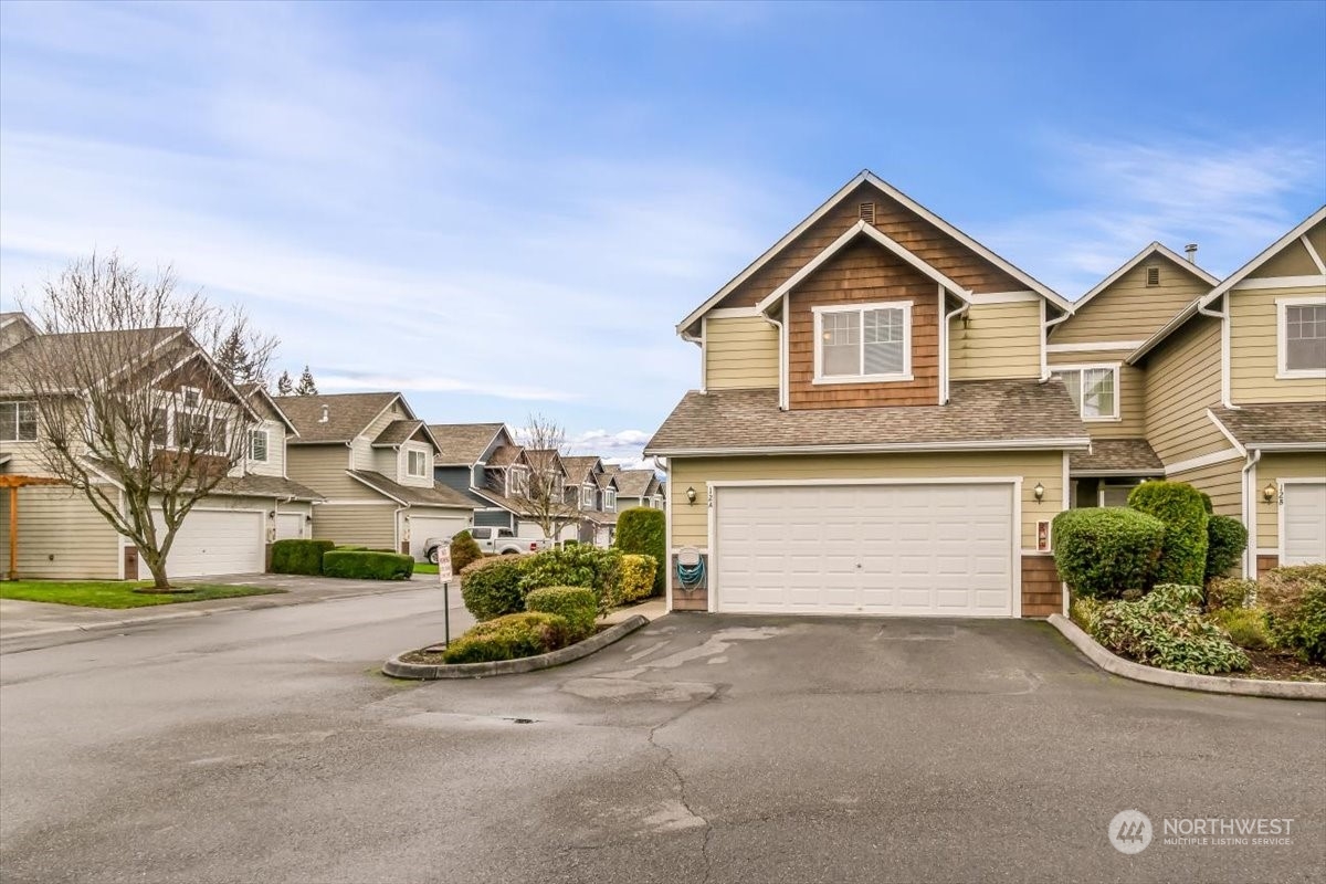 a view of multiple houses with a yard and entertaining space