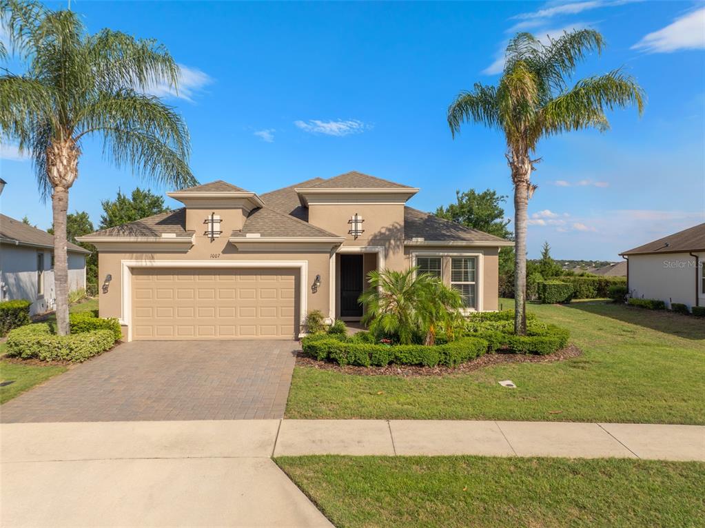 a front view of a house with a yard and palm trees